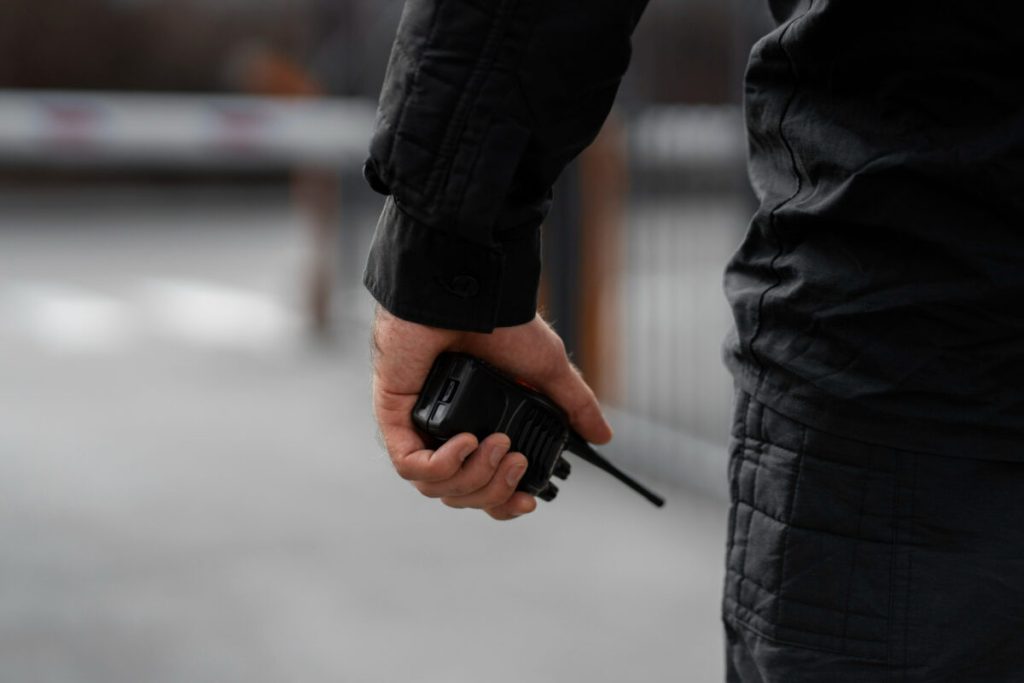 Police officer's hand holding a walkie-talkie