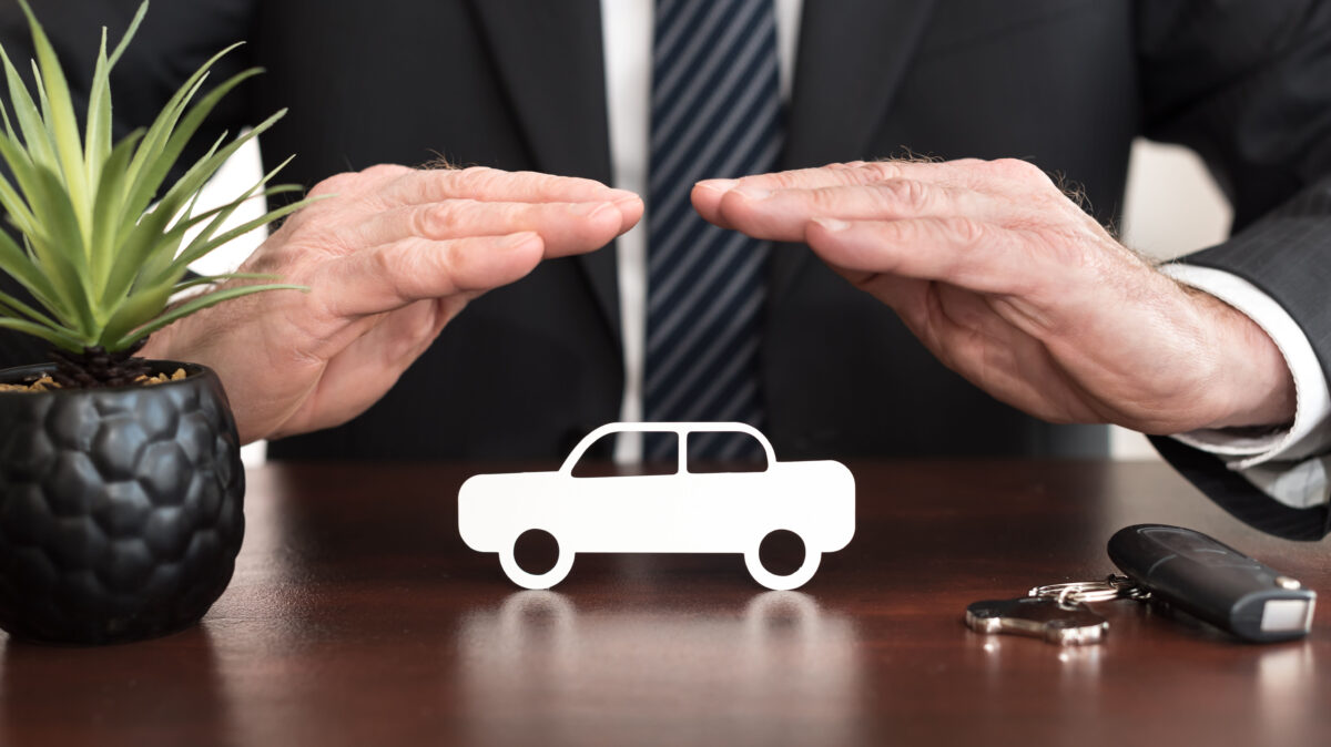 The insurer protecting a car with his hands