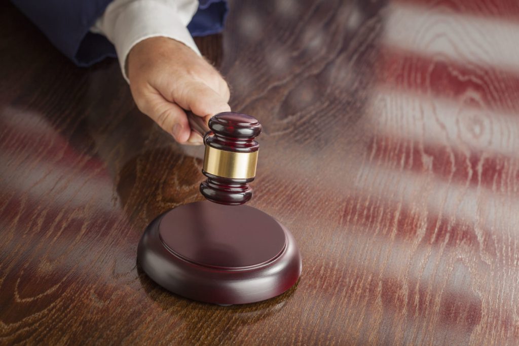 Judge Slams His Gavel and American Flag Table Reflection.