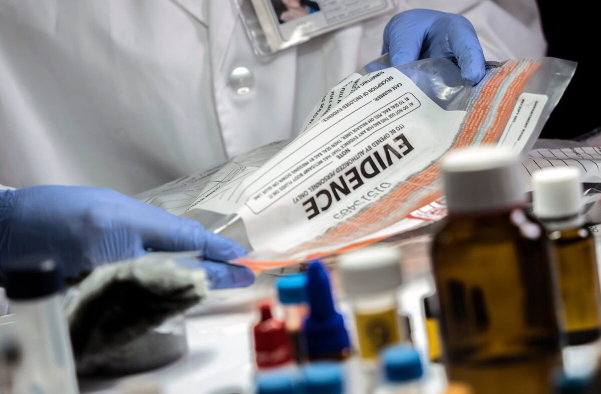 Police specialized taking sample of a bag of evidence in forensic laboratory, conceptual image