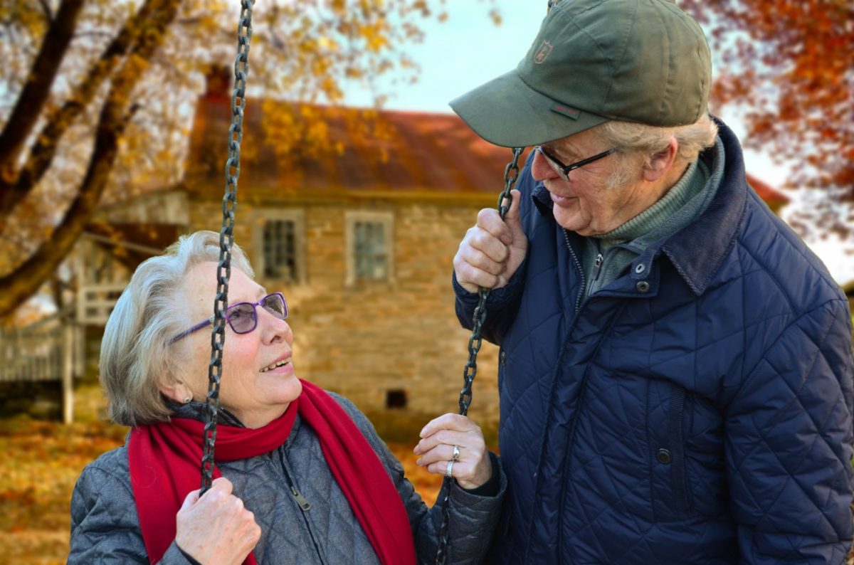 An elderly couple chatting in a park.