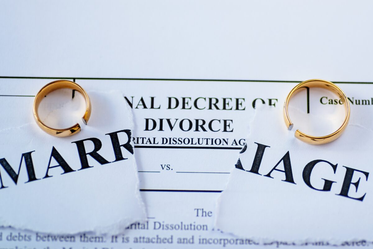 Divorce decree and two broken wedding rings. Divorce and separation concept