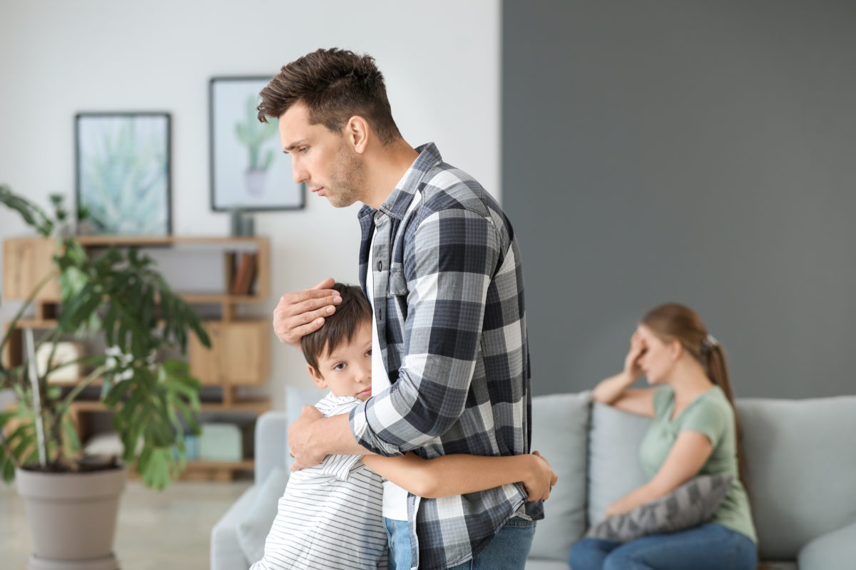 Man calming his son after a family quarrel at home