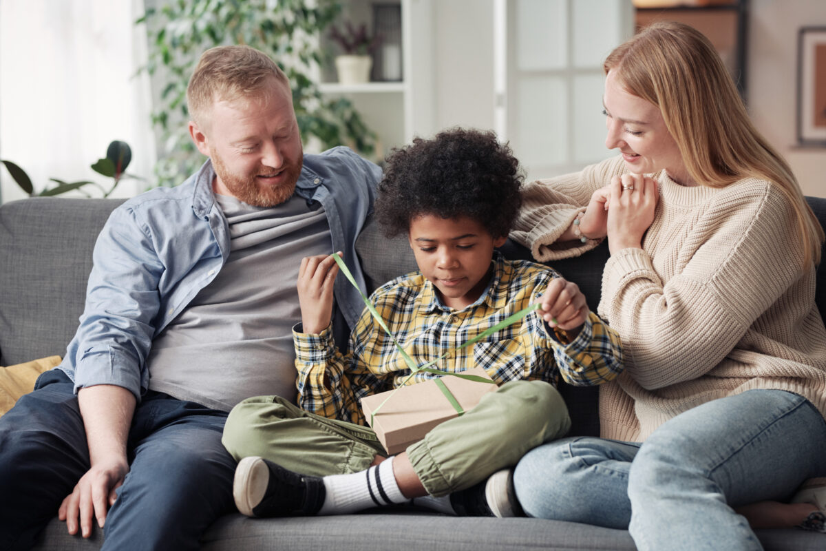 Boy getting present from his foster parents