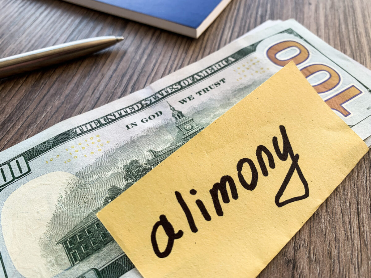 A pile of dollars with signed alimony and money.