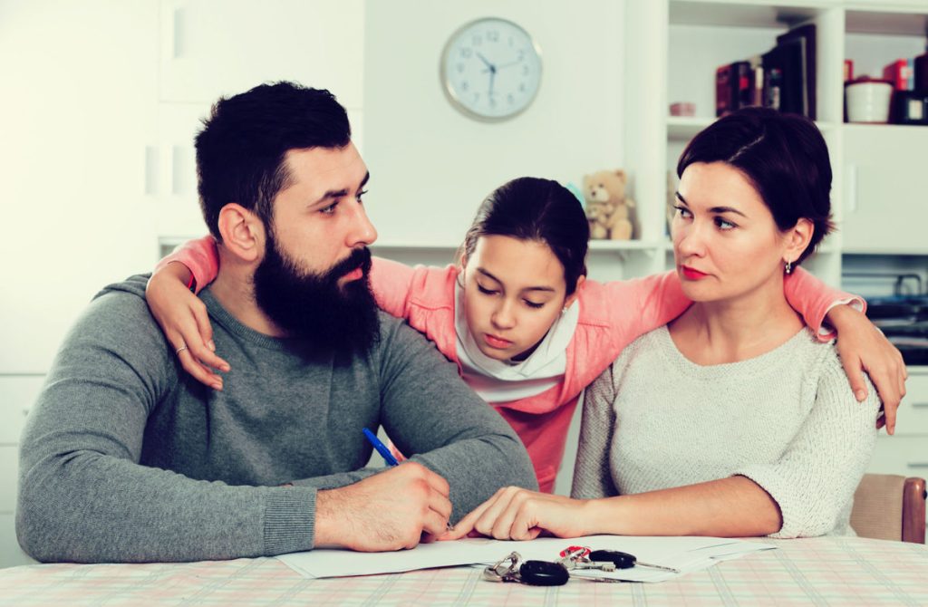 Parents signing papers for divorce