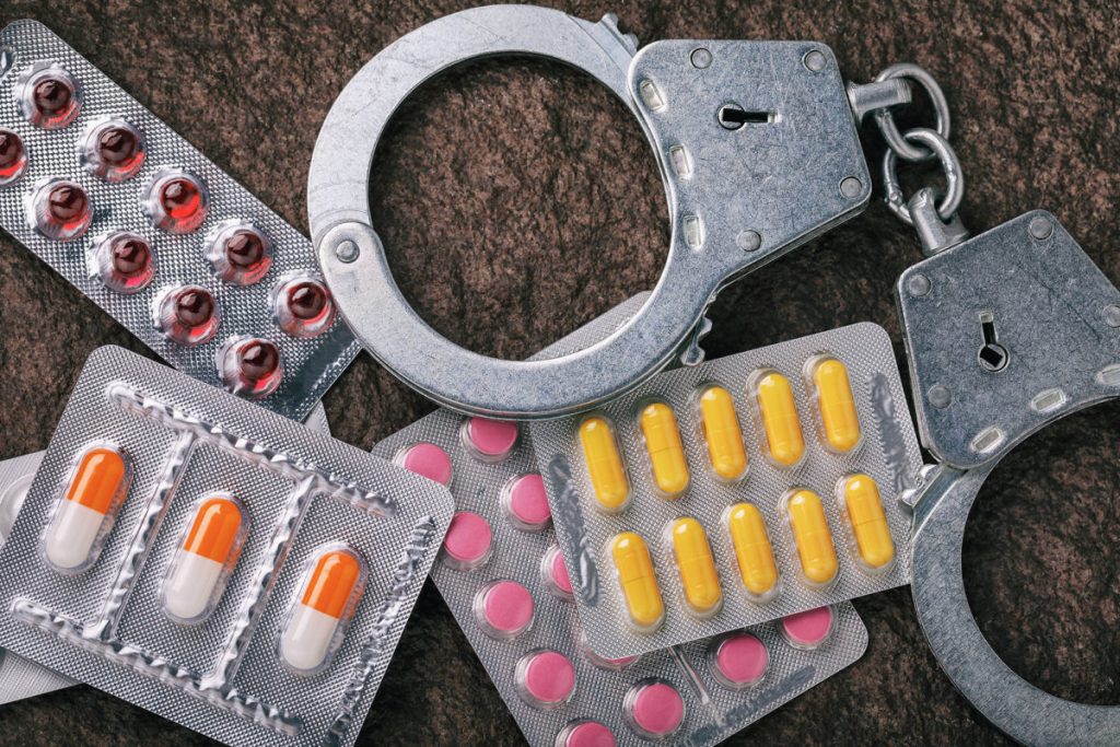 Tablets and handcuffs on stone surface, top view.