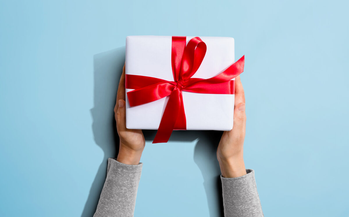 Person holding a Christmas gift box - overhead view flat lay