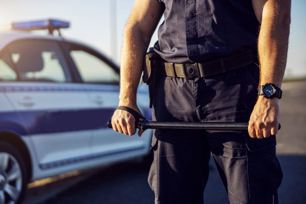 Man in Black Police Uniform Holding a Baton