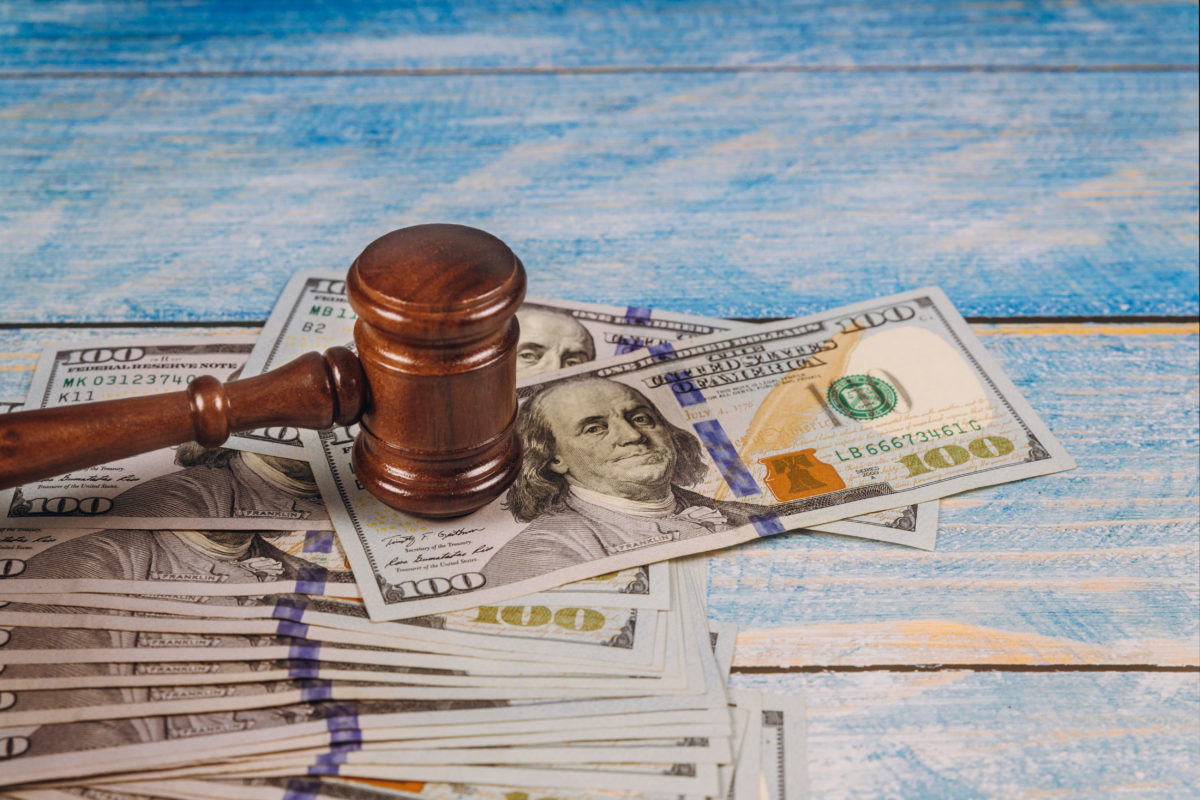 Judge gavel and money on a blue wooden table. Court concept.