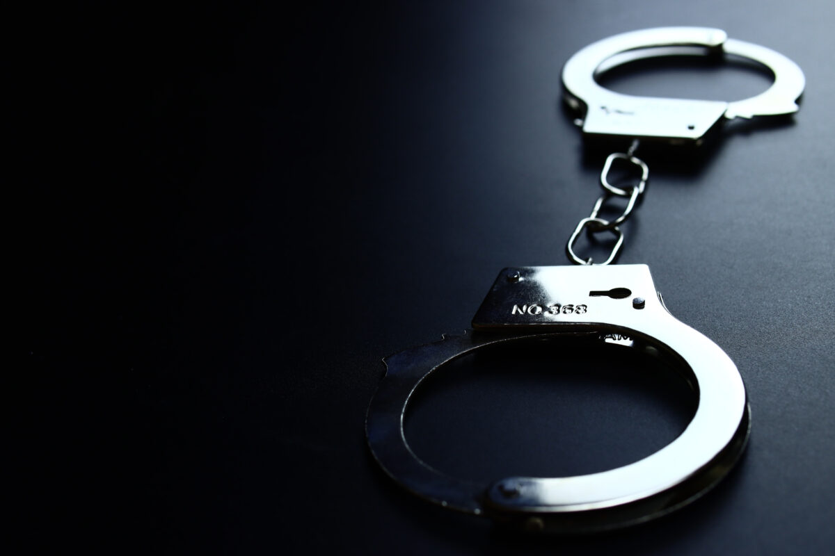 Police metal handcuffs on a black background, close-up, selective focus