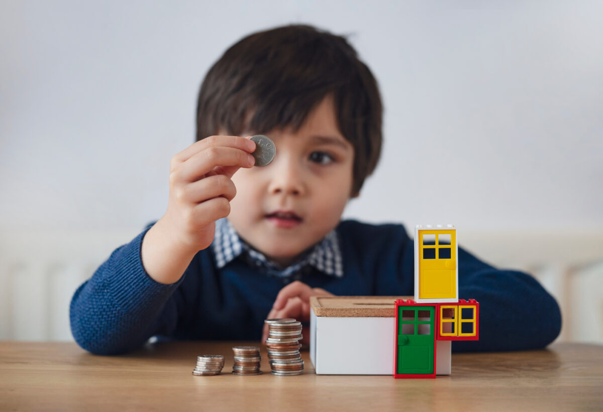 Blurry face of a preschool kid showing 10 pence with a smiling face.