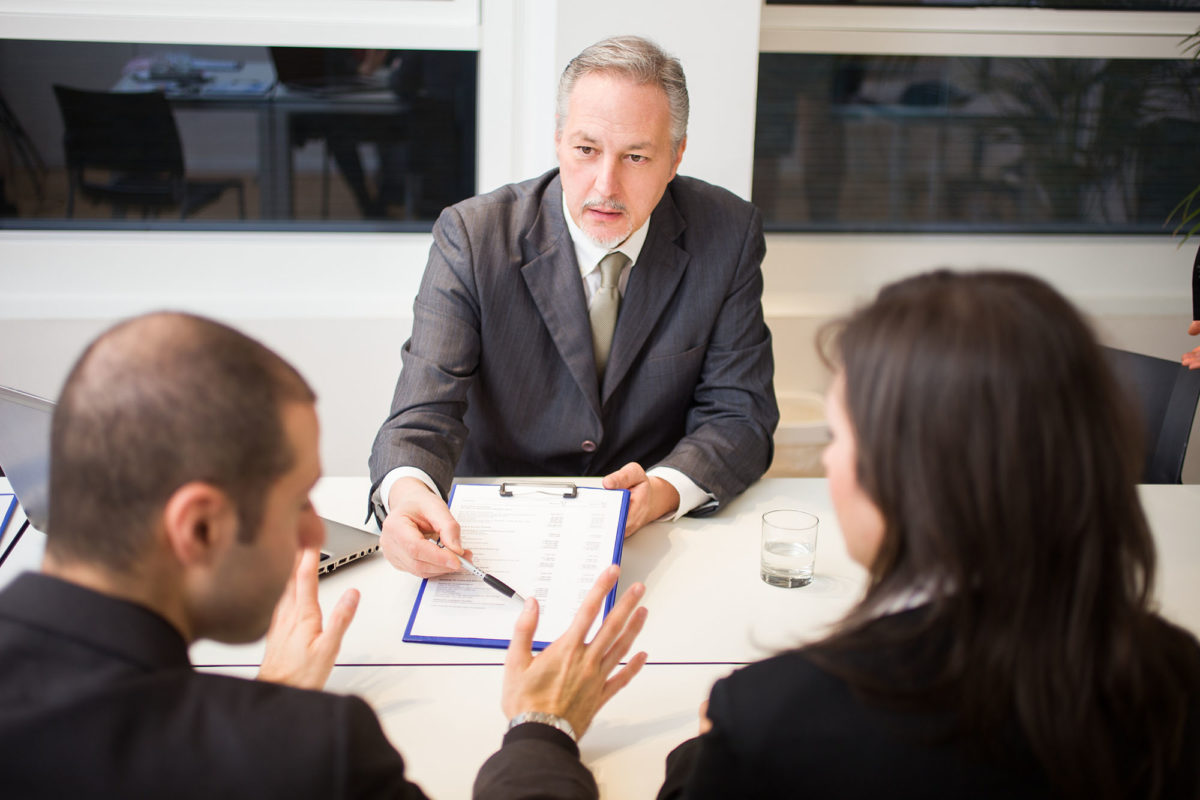 Couple in a law office preparing to sign documents.