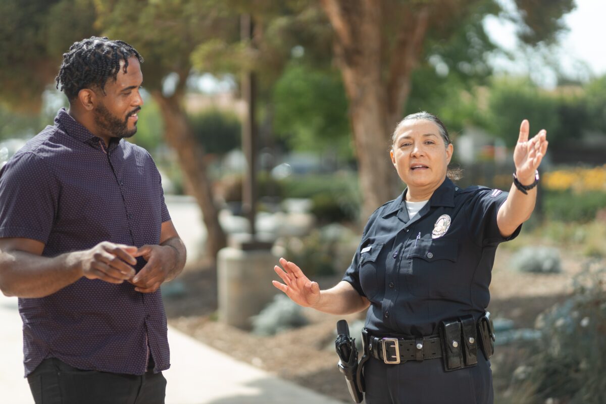 A policewoman is giving instructions to a young man.