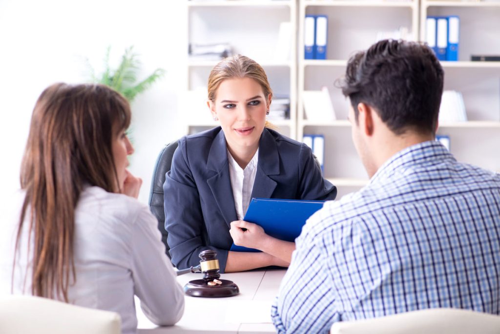 Young family signing marriage documents at lawyer's office