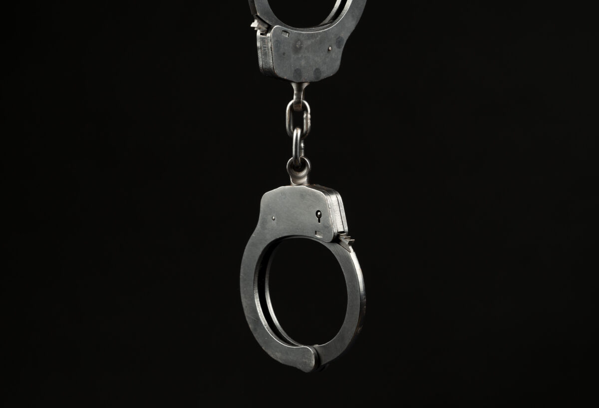 Locked police handcuffs on a black background