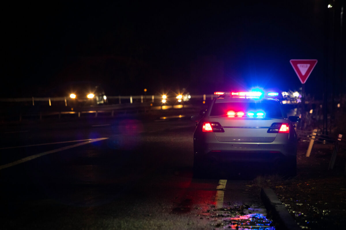 Police emergency flashlights at night from the back on a highway road